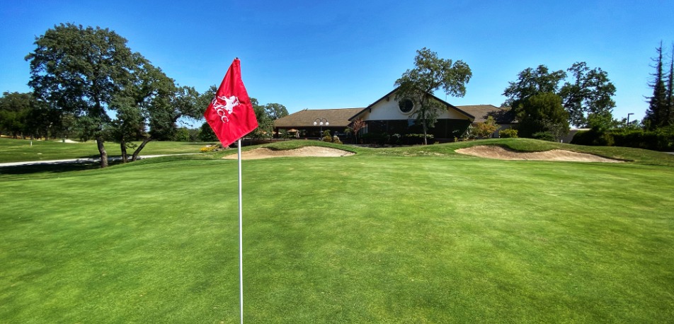 A green on the Rancho Murieta Country Club golf course, with the clubhouse behind it